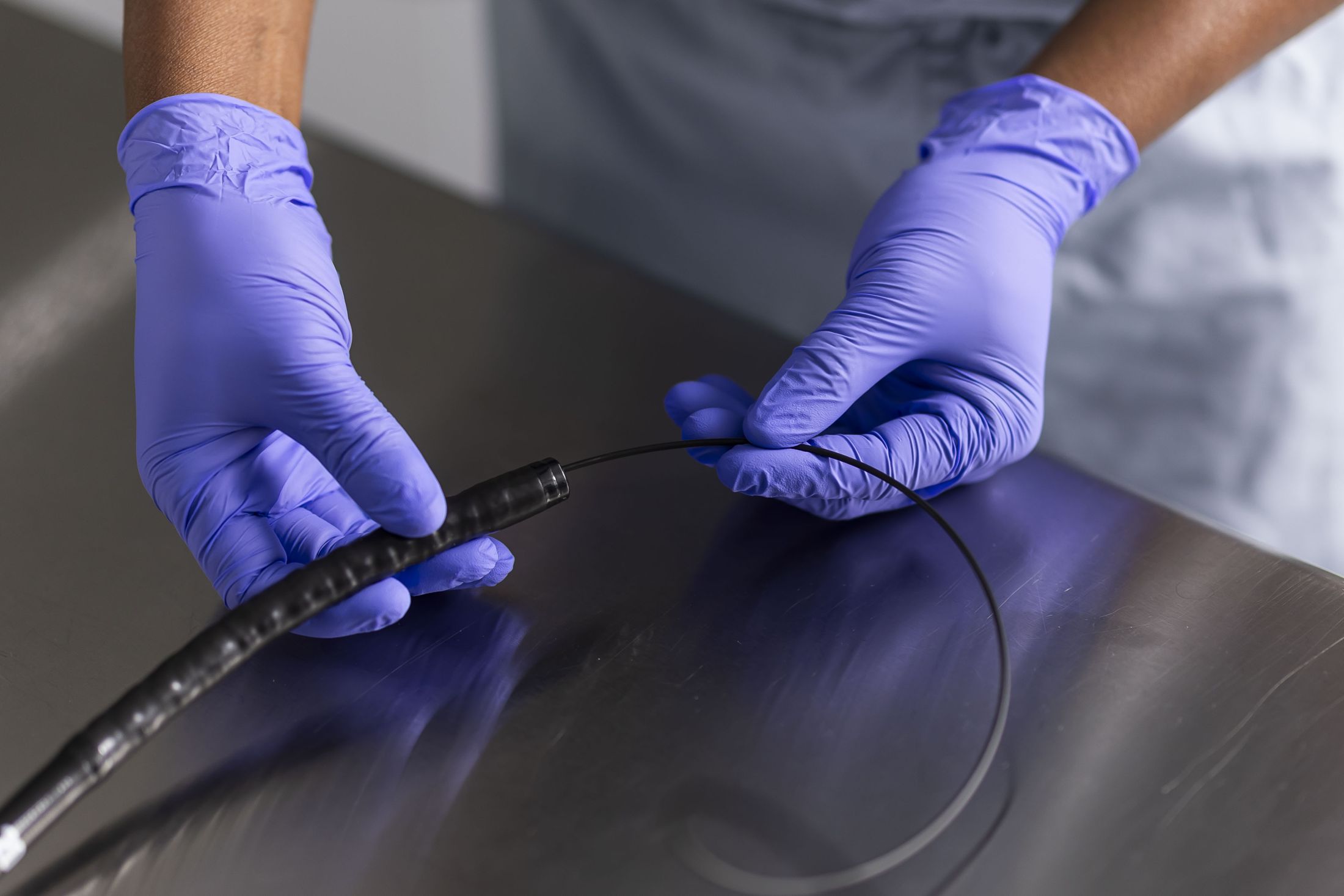 Technician handling a flexible endoscope on the inspection table